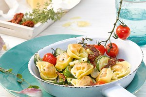 Vegane Tortelloni-Pfanne mit sonnengetrockneten Tomaten, Oliven, Zucchini und Kräutern