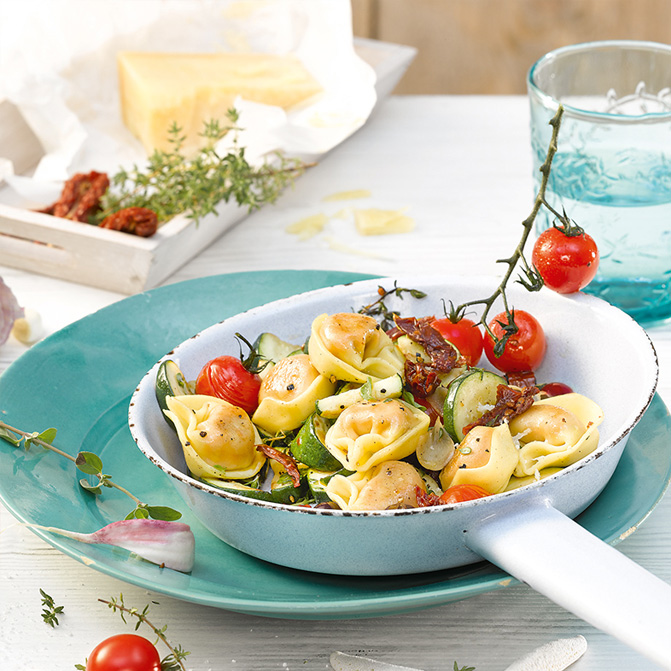 Tortelloni-Pfanne mit sonnengetrockneten Tomaten, Oliven, Zucchini und ...